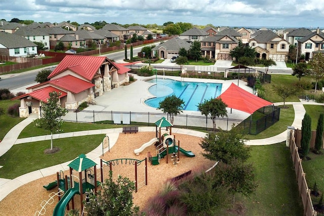 community pool featuring a residential view, playground community, and fence
