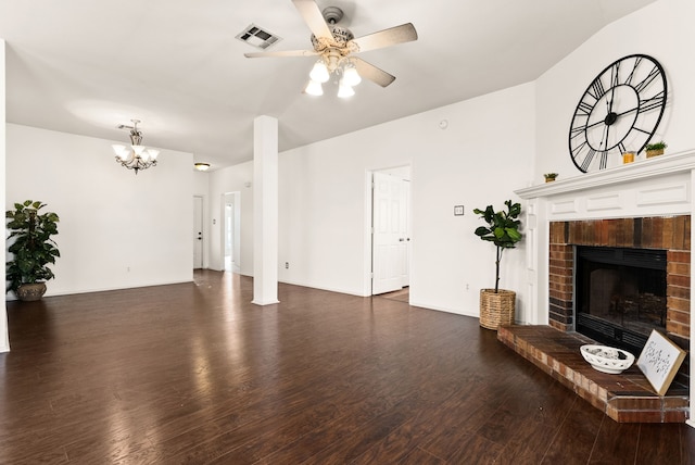 unfurnished living room with ceiling fan with notable chandelier, dark hardwood / wood-style flooring, and a fireplace