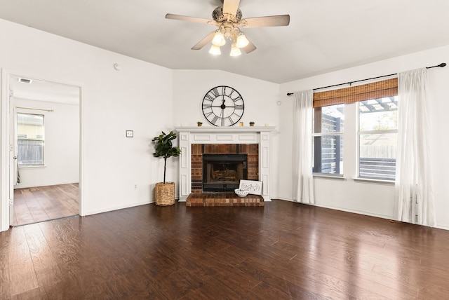 unfurnished living room featuring ceiling fan, dark wood-type flooring, and a brick fireplace