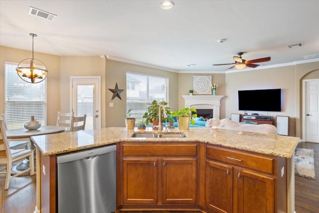 kitchen featuring pendant lighting, sink, stainless steel dishwasher, and an island with sink