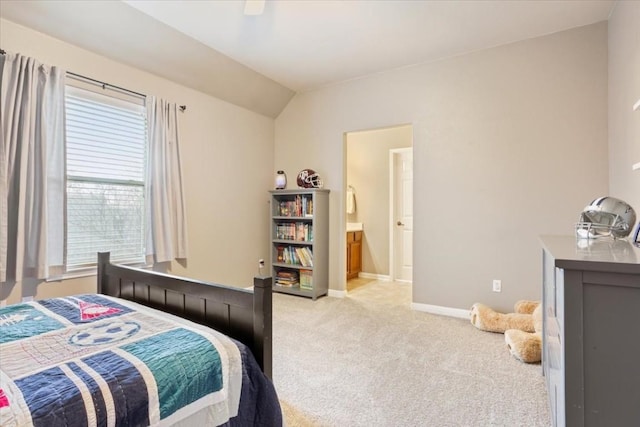 bedroom featuring light carpet, connected bathroom, lofted ceiling, and ceiling fan