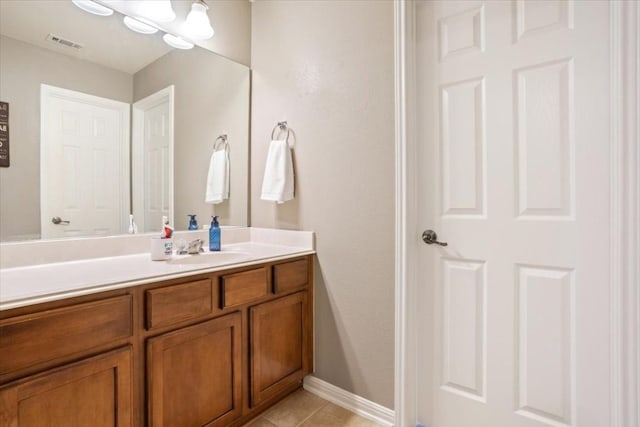 bathroom with tile patterned flooring, vanity, and an inviting chandelier