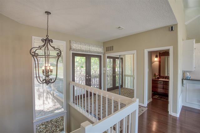 foyer entrance with a notable chandelier, dark wood-type flooring, french doors, and a textured ceiling