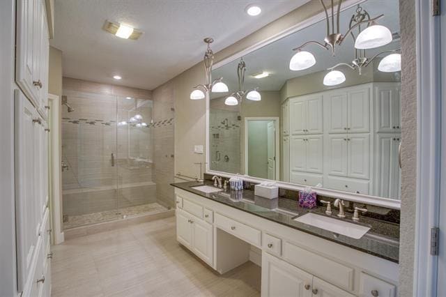 bathroom featuring a shower with door and vanity