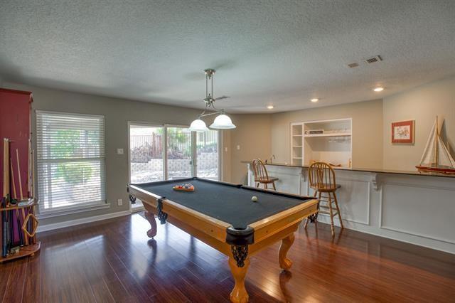 rec room with a textured ceiling, dark hardwood / wood-style flooring, billiards, and indoor bar