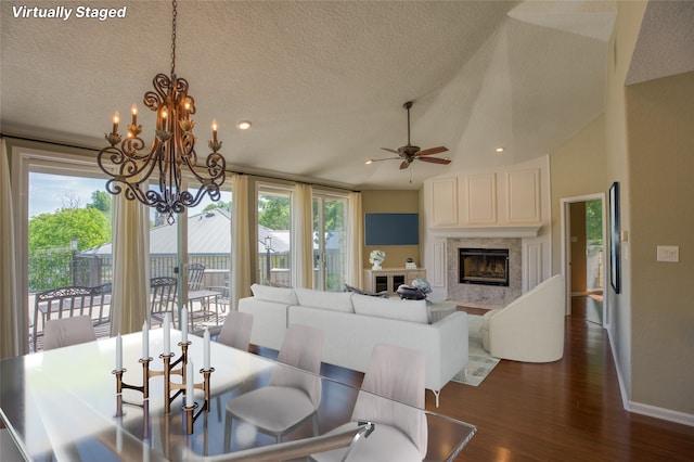 dining space with dark hardwood / wood-style flooring, a fireplace, vaulted ceiling, and a healthy amount of sunlight