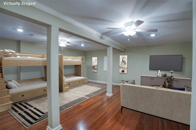 living room with a textured ceiling, dark hardwood / wood-style flooring, and crown molding