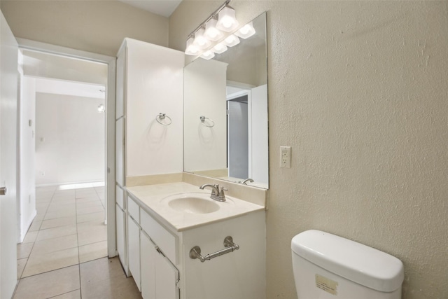 bathroom with tile patterned flooring, vanity, and toilet