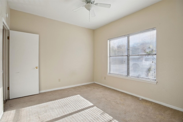 carpeted spare room featuring ceiling fan