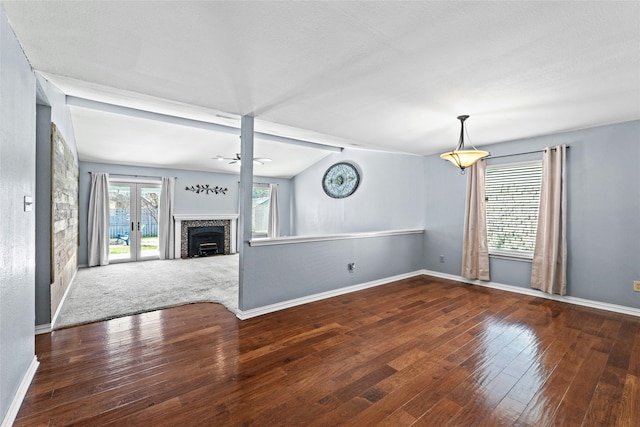 unfurnished living room featuring ceiling fan, vaulted ceiling, dark hardwood / wood-style flooring, and french doors