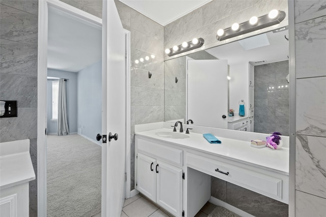 bathroom with tile patterned flooring, vanity, and tile walls