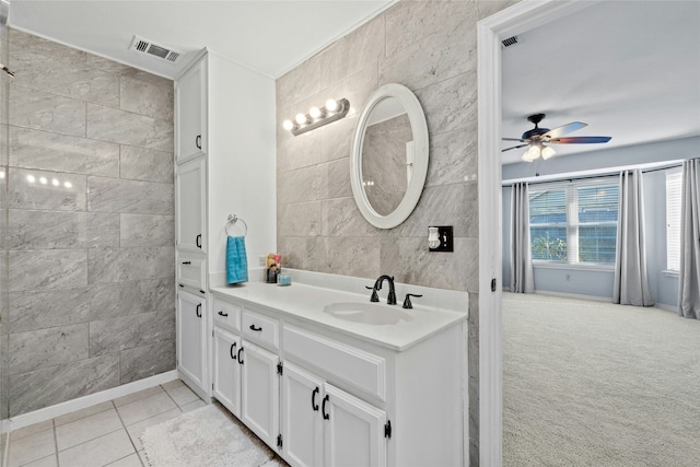 bathroom with ceiling fan, tile patterned flooring, vanity, and tile walls