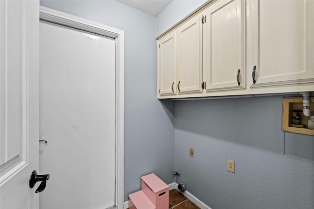 washroom with hookup for a washing machine, tile patterned flooring, and cabinets