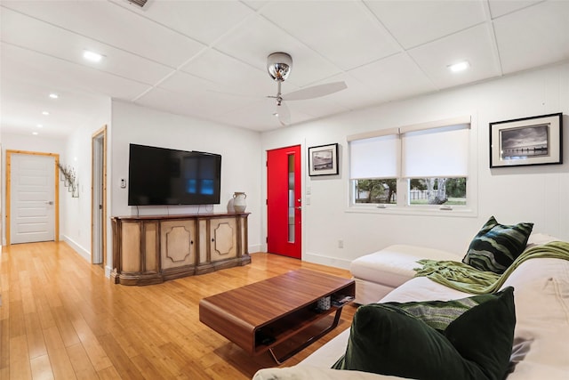 living room featuring ceiling fan, hardwood / wood-style floors, and a drop ceiling