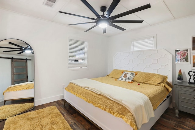 bedroom featuring multiple windows, a barn door, ceiling fan, and dark wood-type flooring