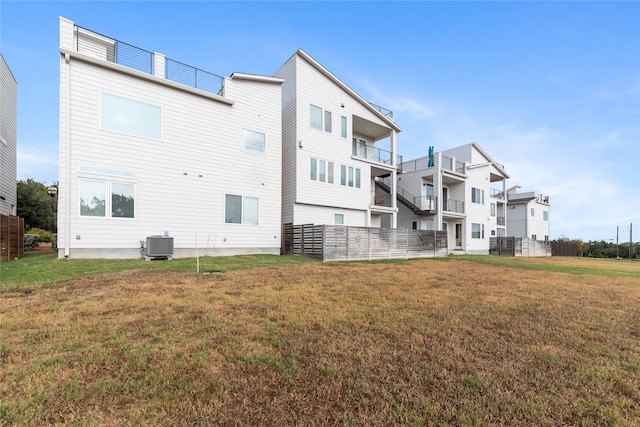 rear view of property featuring a yard and central AC unit