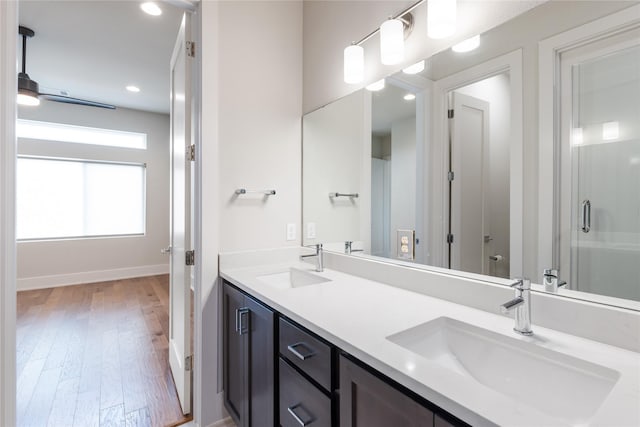 bathroom featuring hardwood / wood-style flooring, vanity, and walk in shower