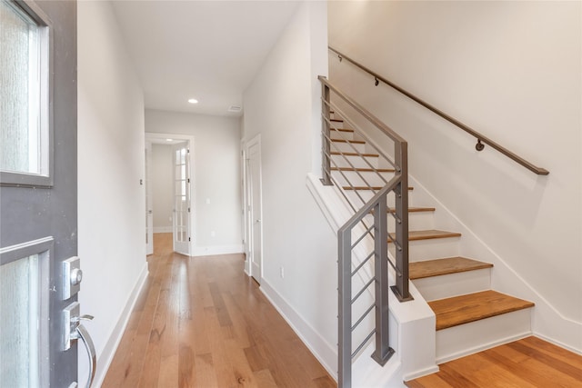 stairs with wood-type flooring and a wealth of natural light