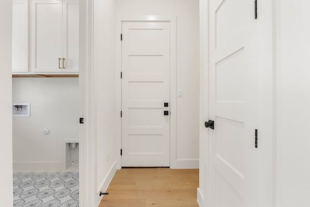 laundry room with cabinets, hookup for a washing machine, and light wood-type flooring