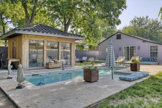 view of swimming pool featuring an outbuilding and a patio