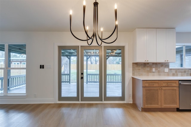 kitchen with white cabinets, backsplash, a wealth of natural light, and dishwasher