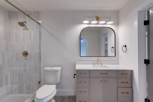 bathroom featuring tiled shower, vanity, and toilet