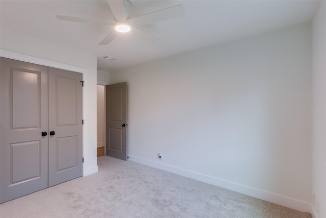 unfurnished bedroom with a closet, ceiling fan, and light colored carpet