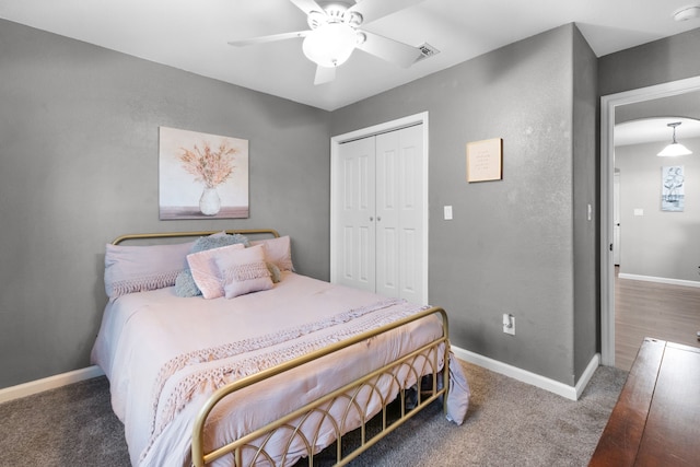 bedroom featuring ceiling fan, dark carpet, and a closet