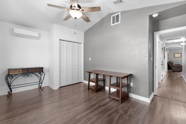 interior space featuring a wall mounted air conditioner, dark wood-type flooring, and lofted ceiling