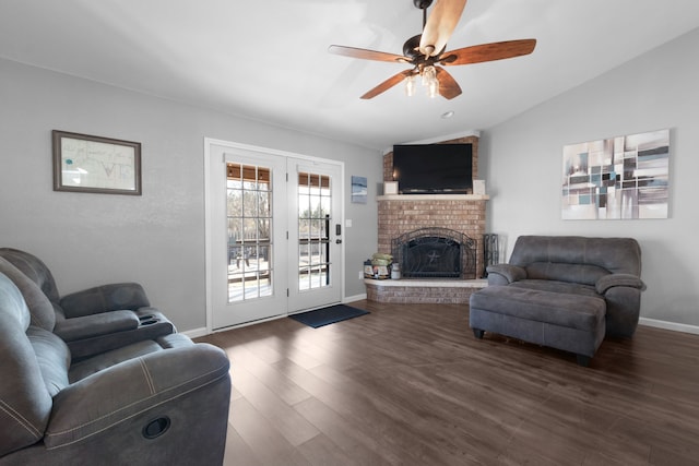 living room with a fireplace, dark hardwood / wood-style floors, ceiling fan, and lofted ceiling