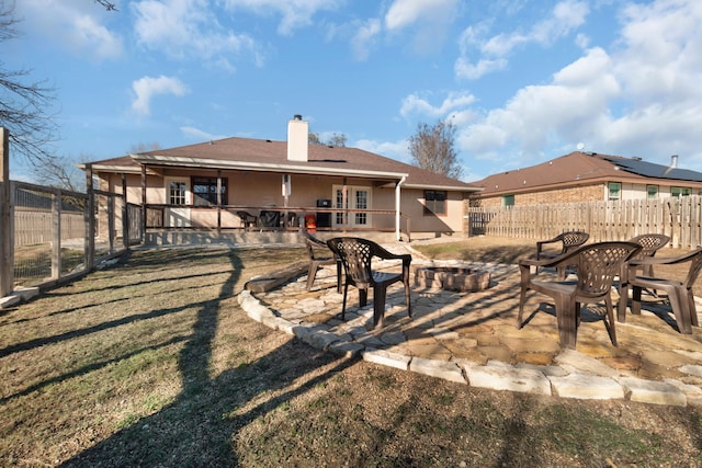 rear view of house with a yard, a patio, and a fire pit