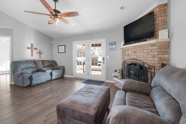 living room with hardwood / wood-style floors, ceiling fan, a fireplace, and vaulted ceiling