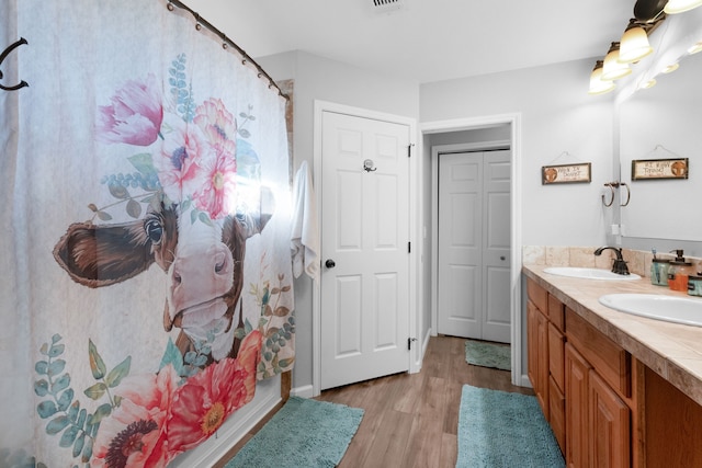 bathroom featuring wood-type flooring, vanity, and walk in shower