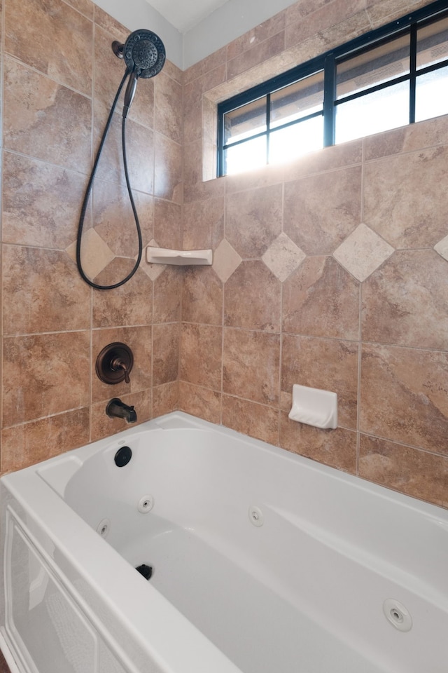 bathroom with tiled shower / bath combo and a healthy amount of sunlight