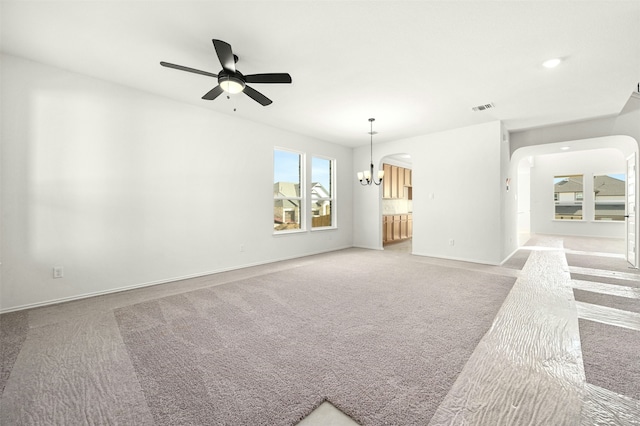 interior space featuring ceiling fan with notable chandelier