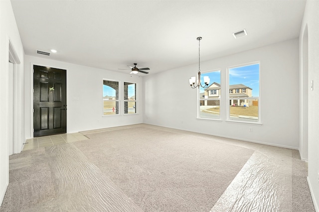 interior space with a healthy amount of sunlight, light colored carpet, and ceiling fan with notable chandelier