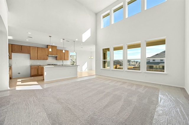 unfurnished living room featuring a towering ceiling