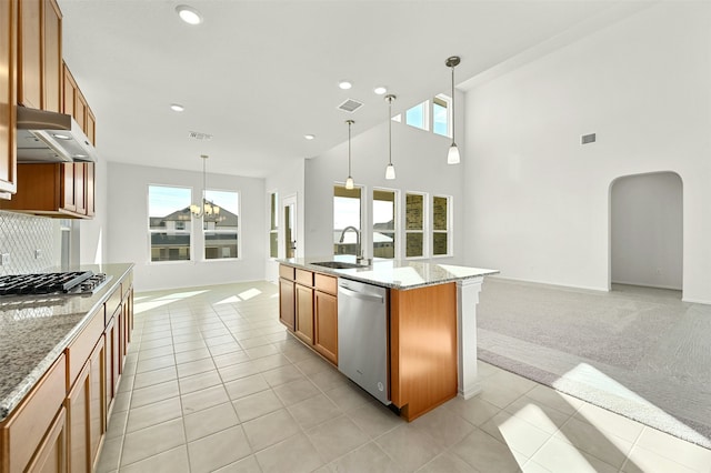 kitchen featuring a center island with sink, appliances with stainless steel finishes, light colored carpet, pendant lighting, and sink