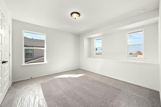 carpeted empty room with a wealth of natural light