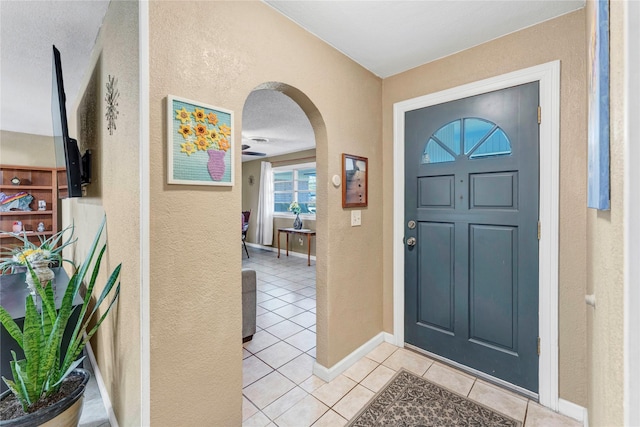 entryway with light tile patterned floors and a textured ceiling