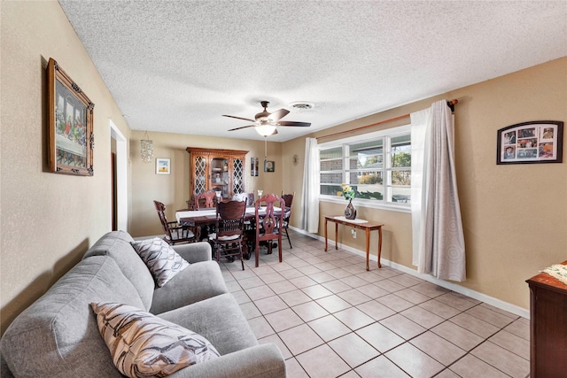 tiled living room with ceiling fan and a textured ceiling