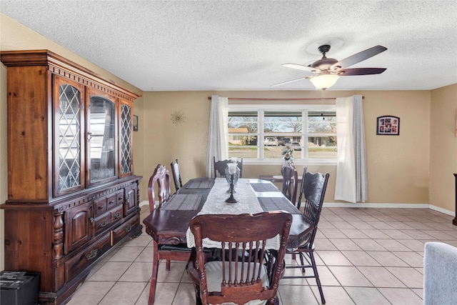 dining space with ceiling fan, light tile patterned flooring, and a textured ceiling