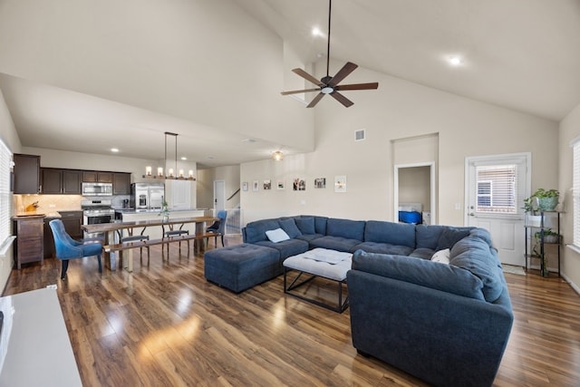 living room featuring high vaulted ceiling, dark hardwood / wood-style flooring, and ceiling fan with notable chandelier