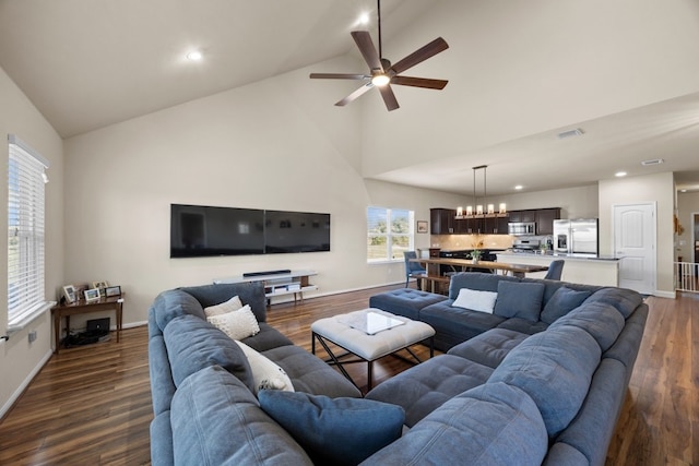 living room featuring ceiling fan with notable chandelier, dark hardwood / wood-style floors, and high vaulted ceiling