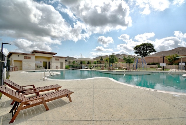 view of swimming pool featuring a hot tub and a patio