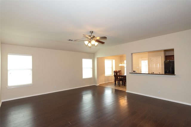 unfurnished room featuring ceiling fan with notable chandelier and dark wood-type flooring