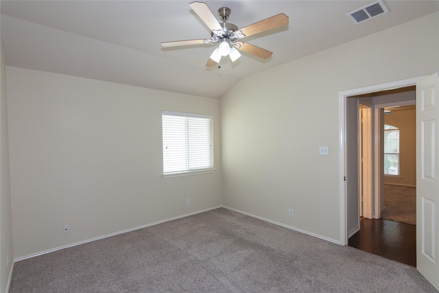 empty room featuring carpet, plenty of natural light, and lofted ceiling