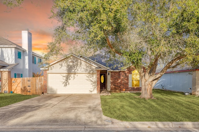 view of front of property with a garage and a yard