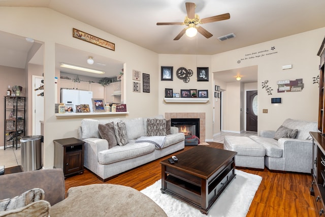 living room with a fireplace, ceiling fan, hardwood / wood-style floors, and lofted ceiling