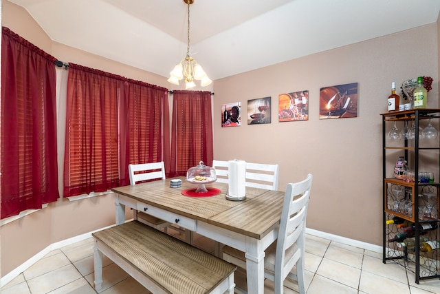 tiled dining area with an inviting chandelier and lofted ceiling